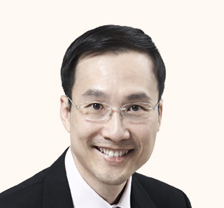 Permanent Secretary for Energy & Carbon, Mr Augustin Lee in suit and glasses, smiling against pale background.